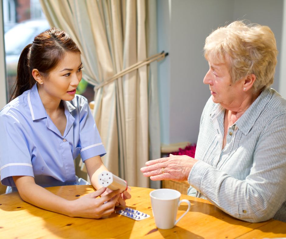 Pflegekraft erklärt einer Seniorin die Medikamenteneinnahme